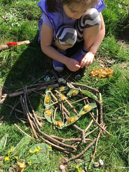 Using sticks, leaves and flowers to create art in the gardern. 