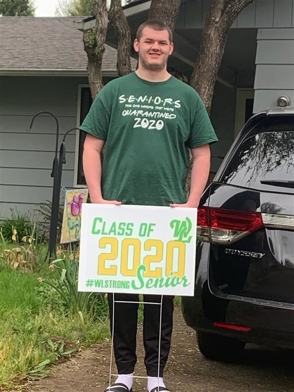 Students show off yard signs delivered by staff. 