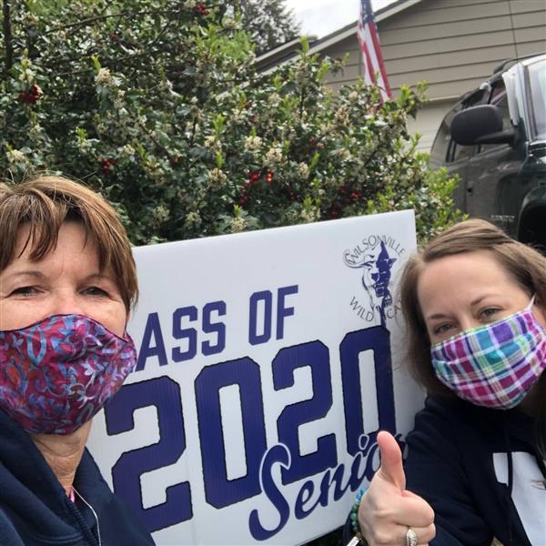 Staff pass out yard signs to students.  
