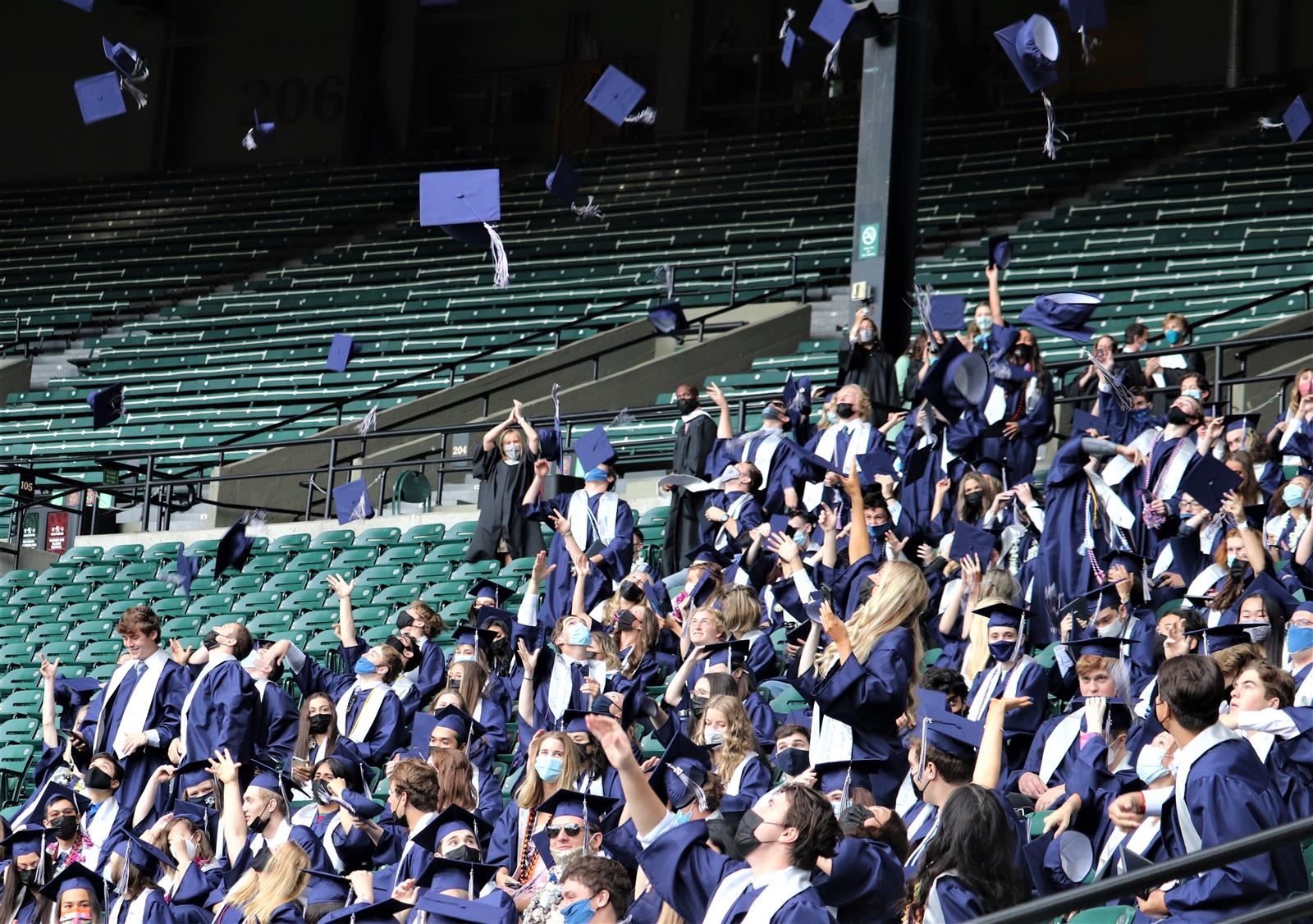 Wilsonville High School graduates throw their caps in the air.