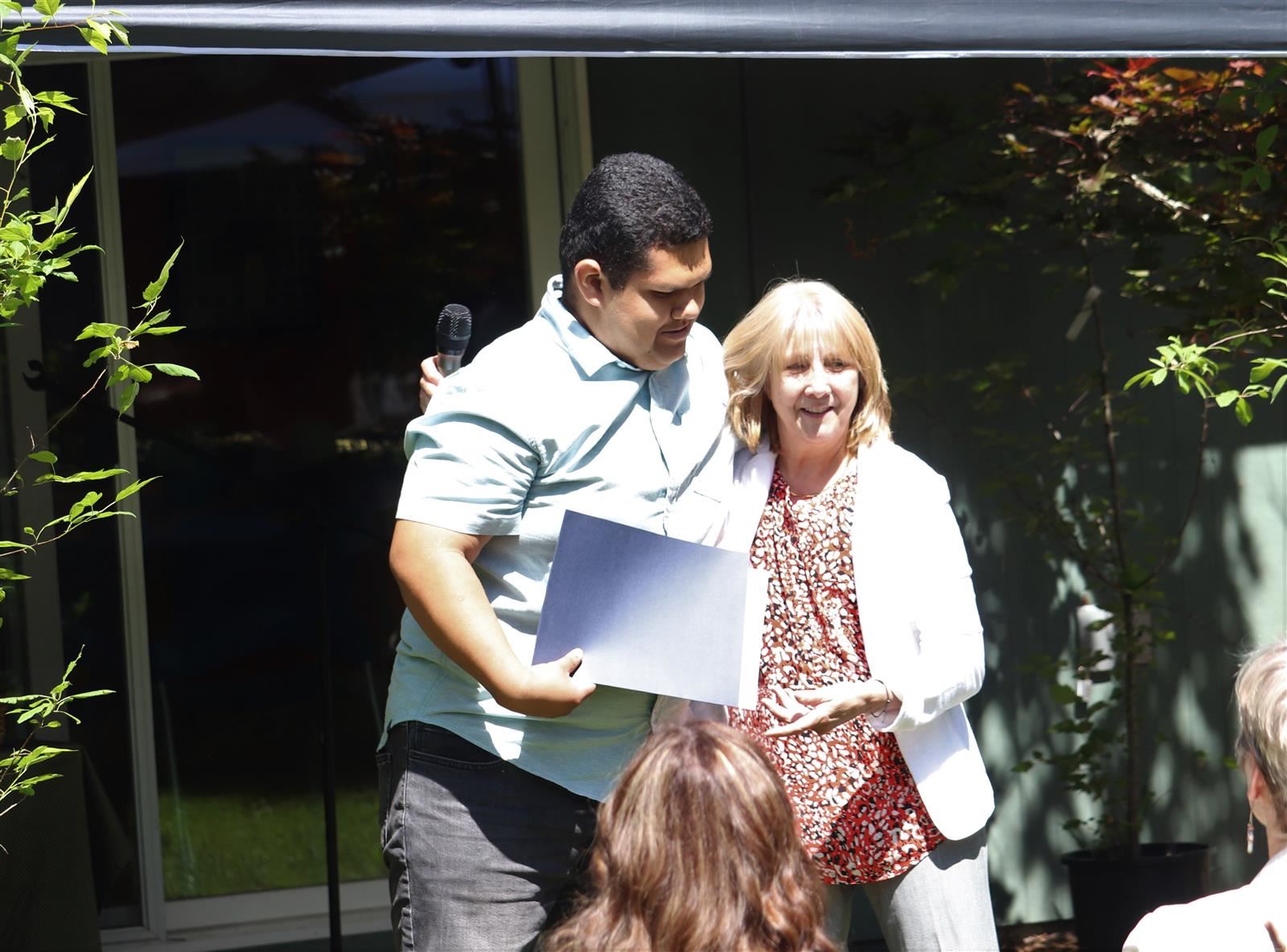 A student gives his teacher a hug.