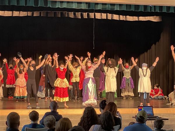 Students perform their original drama production for families.