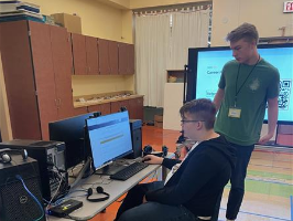 A high school senior helps a 9th grader with their project